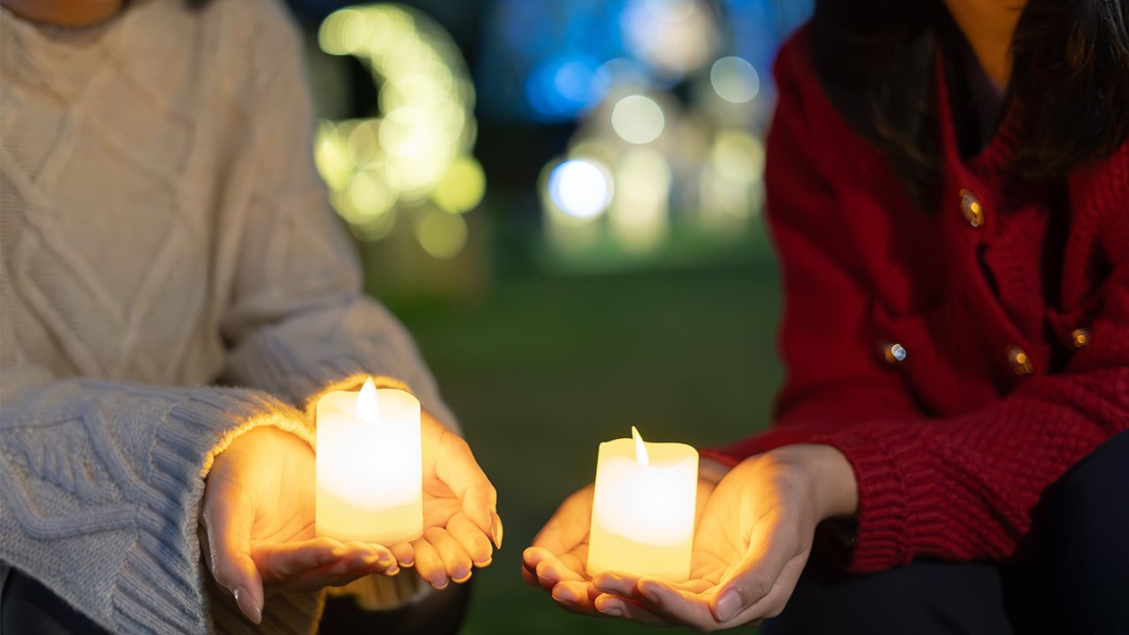 two women holding candles